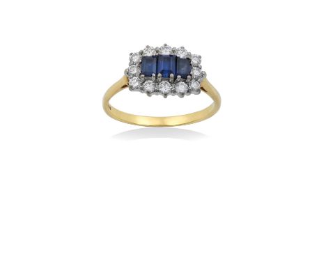 An 18 Carat Gold Sapphire and Diamond Cluster Ringthree graduated step cut sapphires within a border of round brilliant cut d