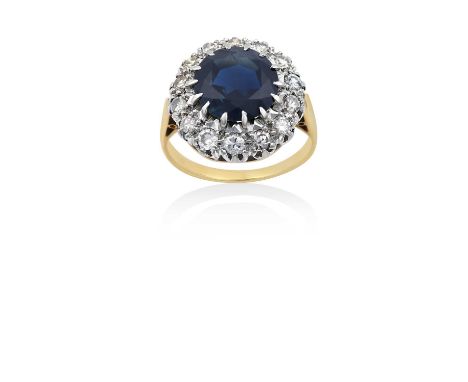 A Sapphire and Diamond Cluster Ringthe round cut sapphire within a border of round brilliant cut diamonds, in white claw sett