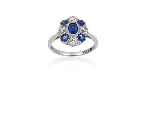 A Sapphire and Diamond Cluster Ringthe oval cut sapphire in a white millegrain setting, within a border of old cut diamonds a