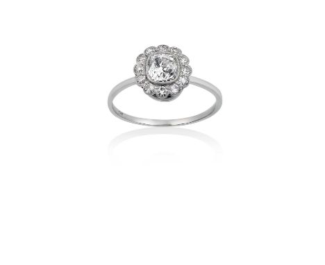 A Diamond Cluster Ringthe old cut diamond within a border of eight-cut diamonds, in white millegrain settings, to a plain pol