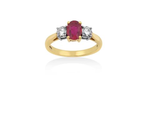 An 18 Carat Gold Ruby and Diamond Three Stone Ringthe oval cut ruby in a yellow claw setting, flanked by round brilliant cut 