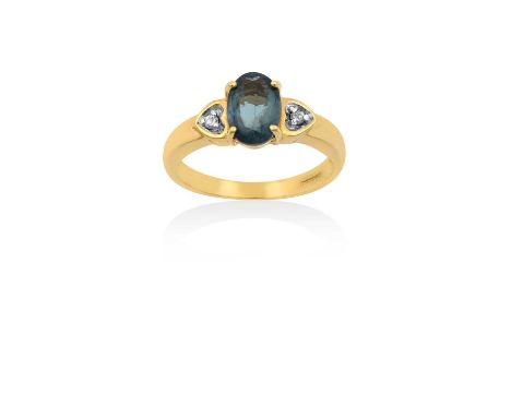 An 18 Carat Gold Alexandrite and Diamond Ringthe oval cut alexandrite in a yellow four claw setting, flanked by round brillia