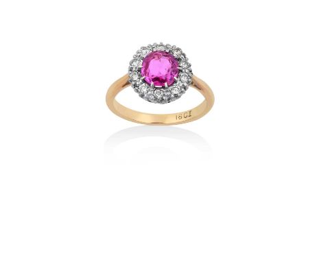 A Pink Sapphire and Diamond Cluster Ring the oval cut pink sapphire within a border of round brilliant cut diamonds, in white