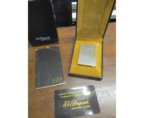 A boxed gold plated and silver finished Dupont cigarette lighter with leaflet and guarantee 