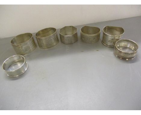 A pair of engine turned napkin rings engraved I and the other engraved II together with five other mixed silver napkin rings 