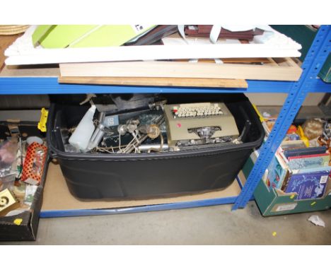 A large plastic crate and contents to include a portable typewriter, light fittings etc.