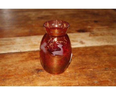 A small ruby glass vase with deer and etched vine decoration