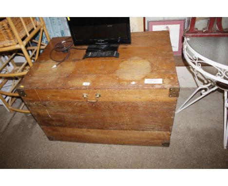 A teak travelling trunk flanked by side carrying handles 