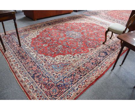 Saroukh Carpet, the raspberry field centred by a sky blue medallion framed by ivory spandrels and meandering vine borders, 36