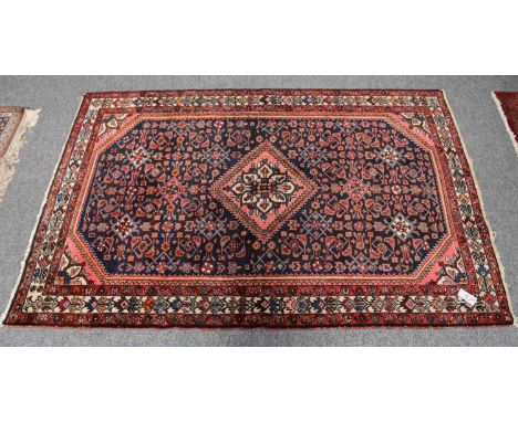 Hamadan Rug, the indigo Herati field centred by a serrated diamond medallion, framed by spandrels and ivory borders, flanked 