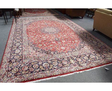 Nejafabad Carpet, the blood red field of scrolling vines and palmettes centred by an indigo and ivory flowerhead medallion, e