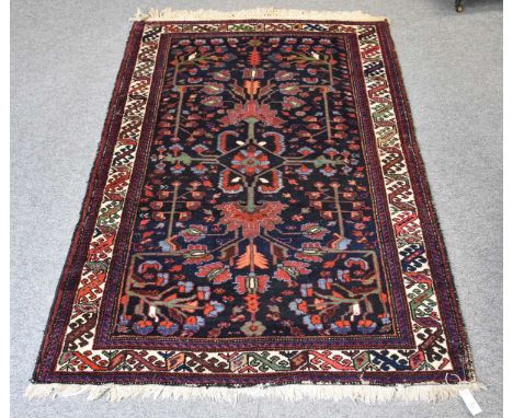 Bakhtiari Rug, the charcoal field centred by a diamond floral medallion surrounded by angular vines, framed by ivory borders 