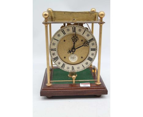 A Thwaites &amp; Reed rolling ball clock, the open movement with silvered dial and named plaque with four corner pillar suppo