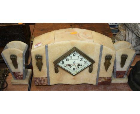 An Art Deco polished hardstone mantel clock garniture, the enamelled dial showing Arabic numerals, having eight-day movement,