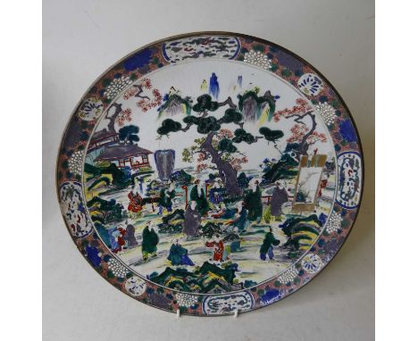 A Japanese porcelain charger, enamel decorated with figures within a landscape, seal mark verso, dia.37cmVery crazed.Large ch