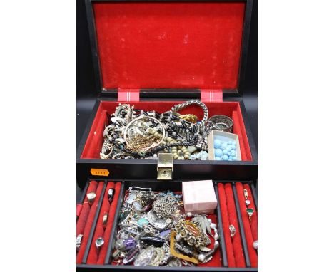 A leather clad jewellery box and contents to include Art Deco style paste set dress ring, various other gold plated dress rin