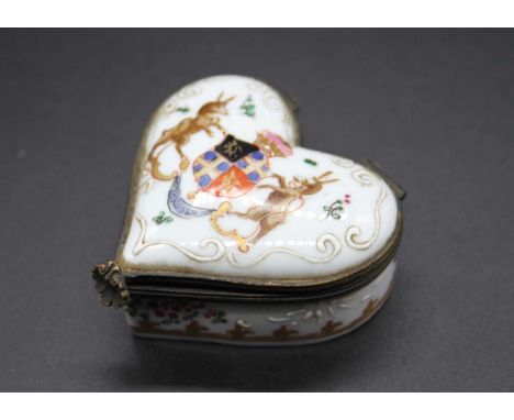 A 19th century porcelain armorial snuff box of heart shape with polychrome and gilt enamel decoration and being brass bound, 