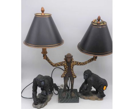 A contemporary novelty table lamp, in the form of a monkey, h.60cm; together with a pair of resin models of gorillas