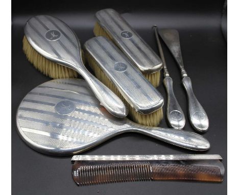 A George V silver dressing table set to include hand mirror, hair brush, clothes brushes, comb, shoe horn and button hook