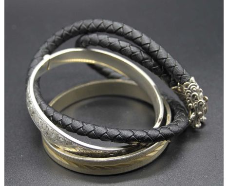 A silver hinged bangle; together with a gilt metal hinged bangle; and a ropetwist necklace (3)