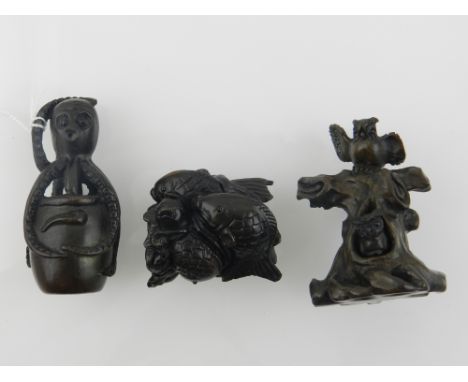 Three resin netsuke, designed as an octopus, owls on a tree stump, and fish. (3)