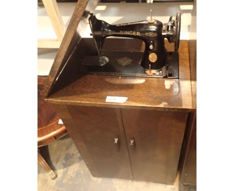 Vintage treadle Singer sewing machine with oak cabinet base. Not available for in-house P&amp;P, contact Paul O'Hea at Mailbo