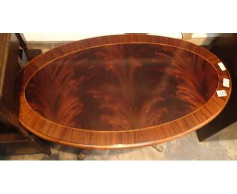 Vintage mahogany oval coffee table with flame top and brass paw feet, L: 100 cm. Not available for in-house P&amp;P, contact 