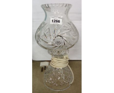 A two piece cut glass table lamp, the base with a spiral hobnail design and the shade with spiraling star design