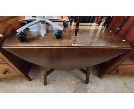 A 1.10m vintage Ercol dark stained elm drop-leaf dining table - finish worn