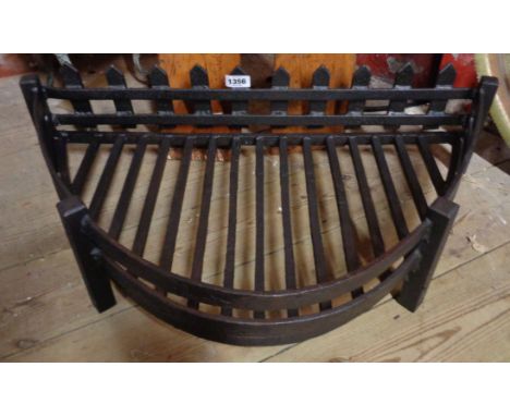 A large wrought iron fire grate of half oval form