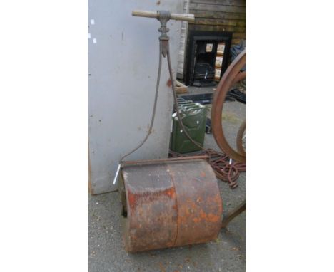 An old iron field roller with replacement wooden handle