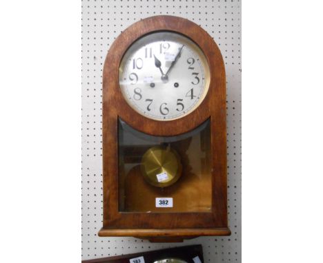 A 20th Century mahogany and mixed wood cased wall clock with bevelled glazed door, visible pendulum and eight day gong striki