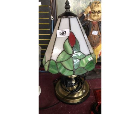 A modern table lamp with Tiffany style glass shade and brassed metal base