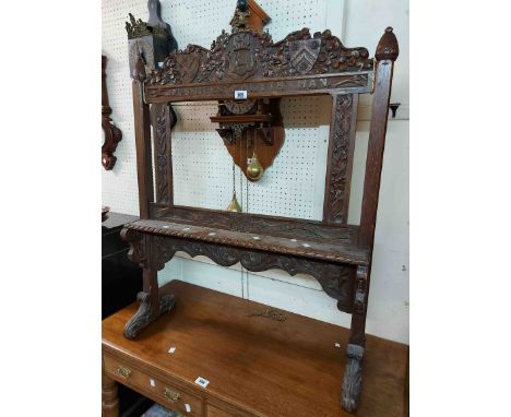 A 78cm late Victorian carved oak screen frame with armourial, text and acanthus scroll decoration and bracketed shelf under, 