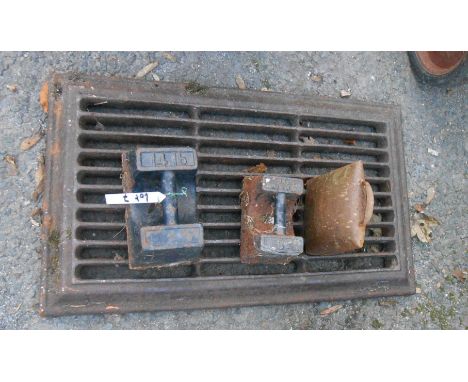 An old cast iron fire grate - sold with two cast iron weights and a vintage cowbell