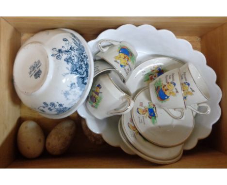 A wooden box containing a quantity of assorted ceramic items including child's tea set, wooden and ceramic brooding eggs, etc