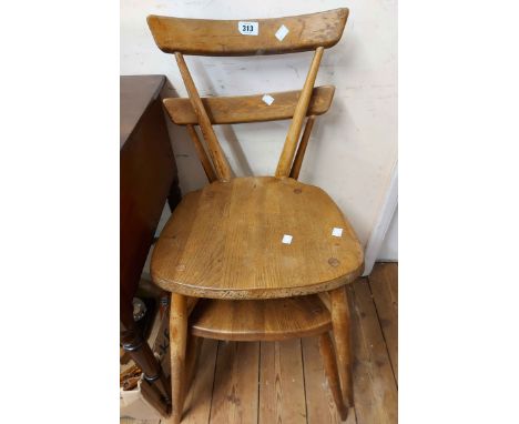 A pair of vintage Ercol light elm stacking kitchen chairs with curved back rails and solid moulded seats - finish worn