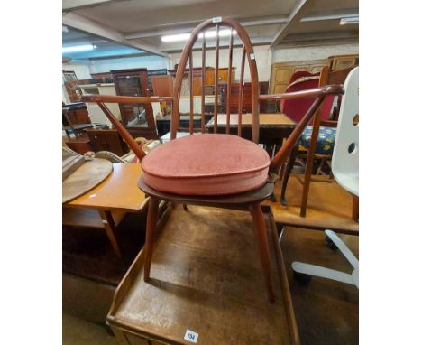 An Ercol dark stained elm seated hoop stick back elbow chair with B.S. 1960 kitemark stamp and original label