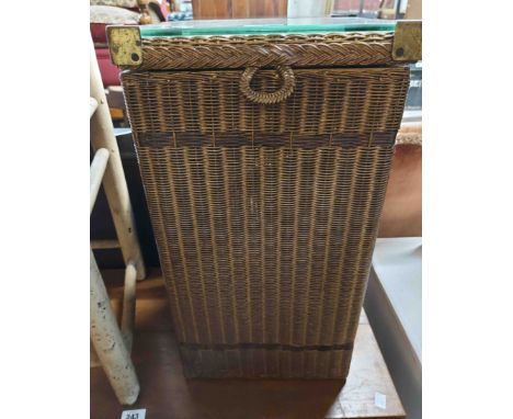 A vintage Lloyd Loom laundry basket with glass inset top and original gold sprayed finish and original paper label to base