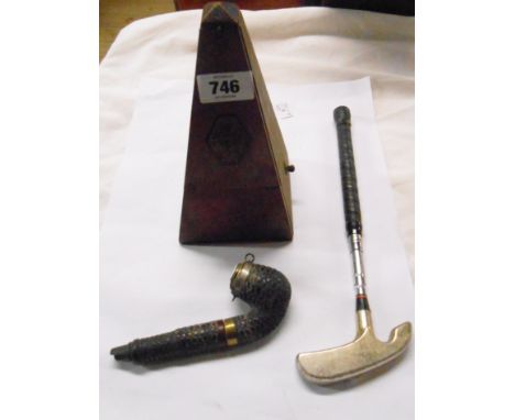 An old wooden metronome, a briar pipe and an extendable golf putter