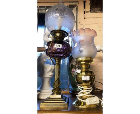 A Victorian Duplex oil lamp with amethyst glass shade, set on brass Corinthian column base with chimney and frosted glass glo