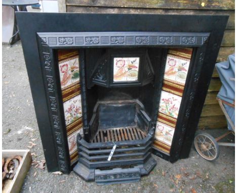 A 97cm Victorian black painted cast iron fire grate with repeat floral pattern to edges, ceramic tile inset border and simila