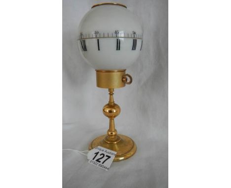A globe shaped clock on stand, in need of repair.