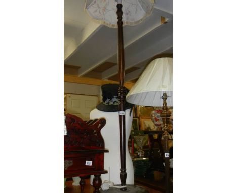 A wooden standard lamp with shade.
