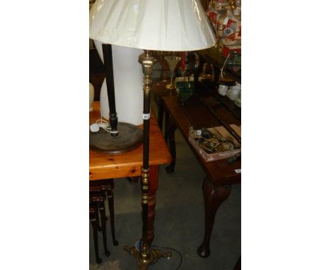 A brass standard lamp with shade.