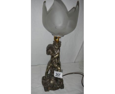 A cherub table lamp with glass shade.