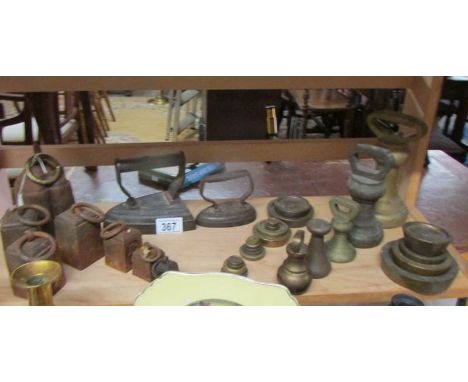 A shelf of brass weights, iron weights and flat irons.