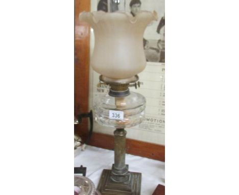 A brass oil lamp with glass font and shade.