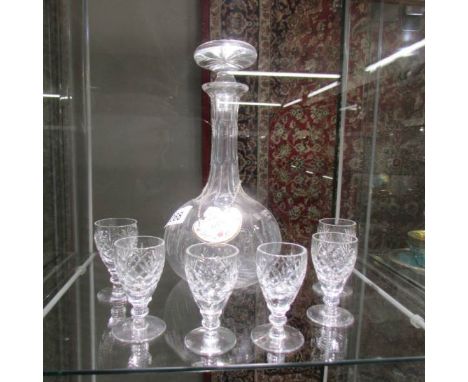 A glass decanter with ceramic label and 6 glasses.