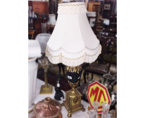 An urn shaped table lamp with shade.